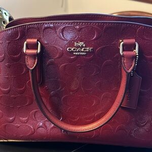 Coach handbag in burgundy with gold trim and strap